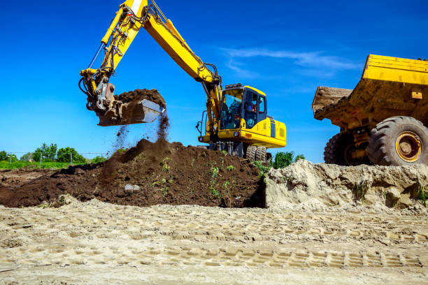 istock Excavator is loading a truck with ground on building site 1171265400