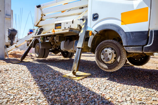 Photograph capturing a close-up of a construction crane arm and its hook, working at a job site handling metal materials. The environment showcases urban architecture and represents industrial and construction themes