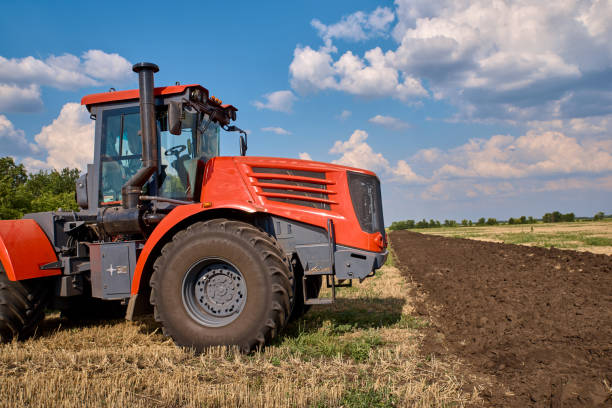 istock Tractor plows field, cultivators soil for sowing 1171270261