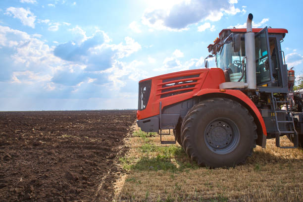 istock Tractor plows field, cultivators soil for sowing 1171271122