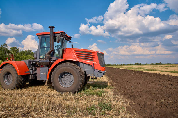istock Tractor plows field, cultivators soil for sowing 1171278075