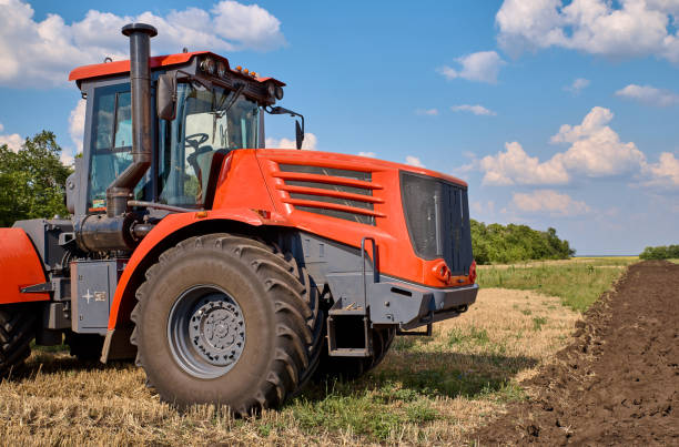 istock Tractor plows field, cultivators soil for sowing 1171278119