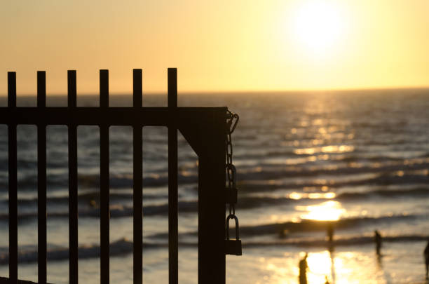istock Lock on a grid at Newport Beach pier highlighted by sunset. 1171278230