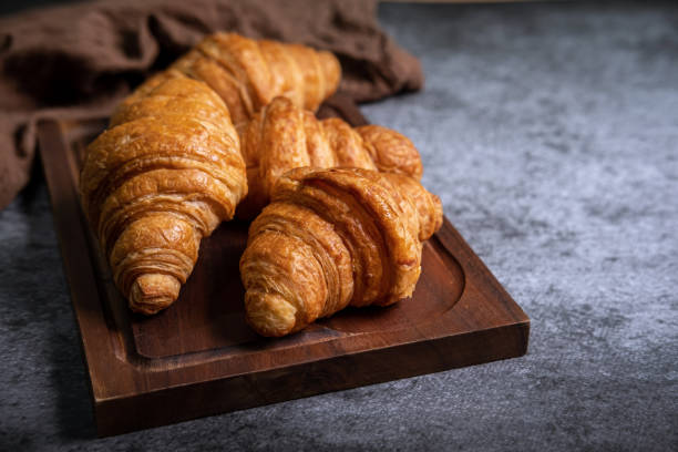 istock Breakfast with fresh croissants on wooden board 1171286261