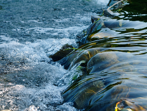 Directly above looking down at rushing rapid river from snowmelt in the mountains. Photographed using slow shutter motion blur in New Zealand.