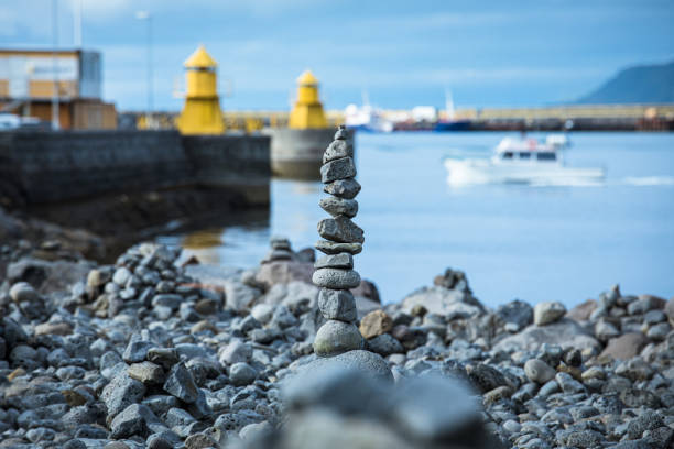 Focus is on the stones with boats and harbour in the background.