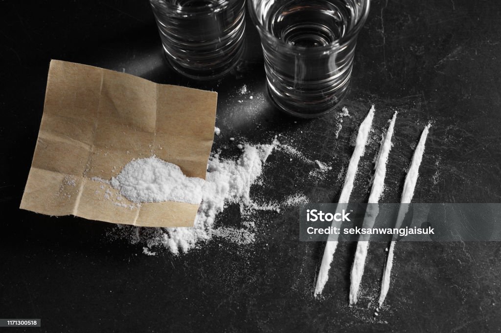 close up pile of cocaine in paper and vodka on black background, cocain on  black background Stock Photo