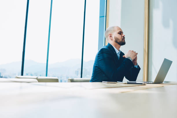 istock Smart financial manager in formal wear thinking on developing own business plan sitting at digital computer in modern office interior at meeting table.Contemplative proud ceo pondering on productive strategy 1171301472