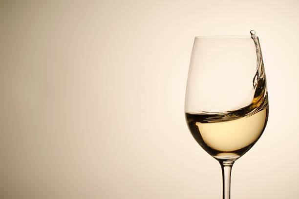 caídas suspendidas y salpicaduras de vino blanco en copa - wine pouring wineglass white wine fotografías e imágenes de stock