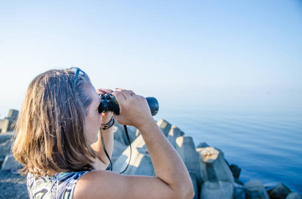 istock Woman looking at sea with binoculars 1171307141