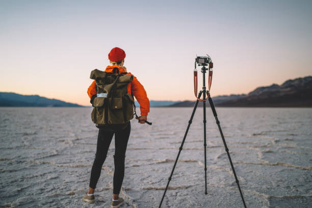 istock Back view of female  with touristic backpack using modern equipment for making photos of landscape and wild nature,professional woman photographer using tripod during work in expedition in desert 1171307435