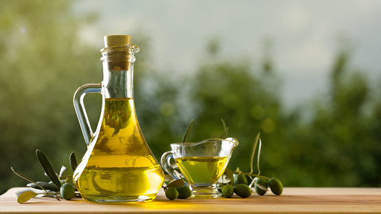 Olive oil bottle on wooden table, natural oils concept