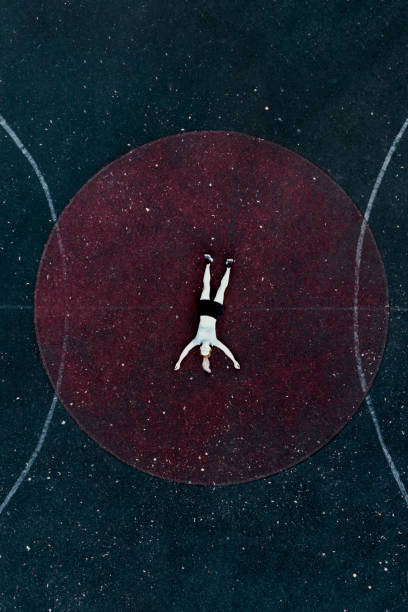 istock 40 years old woman lying on stadium 1171318882