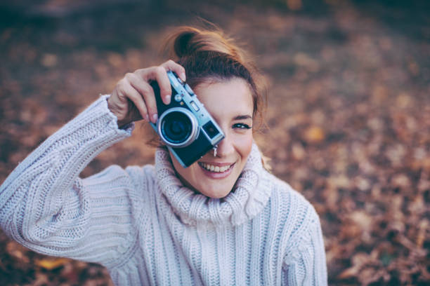 Beautiful girl taking photos with retro camera