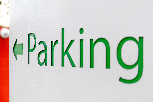 white parking sign with arrow
