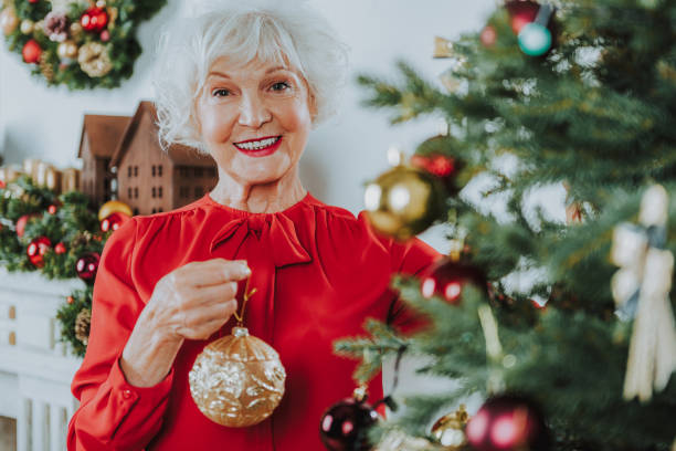 istock Happy senior lady is standing with Christmas toy 1171326057