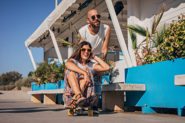 istock Playful couple having fun with skateboard 1171326068