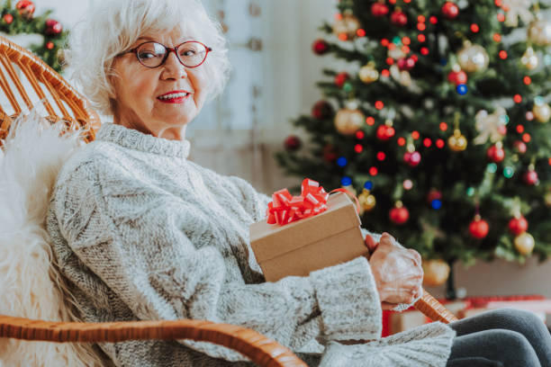 Old lady in glasses holding Christmas gift