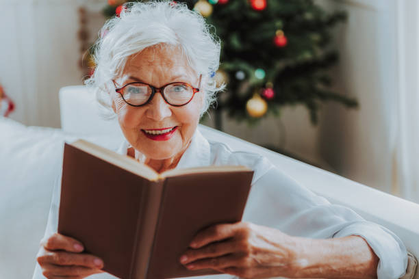 istock Happy gray-haired senior woman is reading book 1171326146