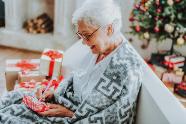 istock Smiling senior woman writing congratulation on postcard 1171326262