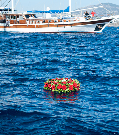 Memorial wreaths in front of the yacht on the sea