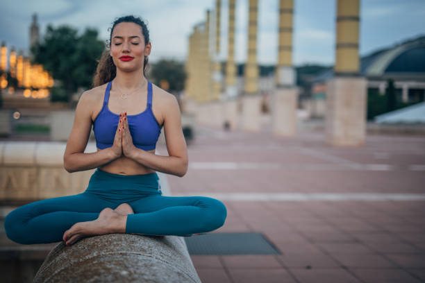 Woman doing yoga exercises and meditating outdoors
