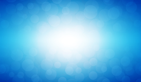 Soft pastel blue colour shining star horizontal background stock photo. Looks like twinkling lights light shiny background. Vignette, vignetting, copy space. No people. No text. Apt for party, Xmas, Christmas, New Year's eve, birthday party celebration backdrop, wallpaper,  romantic gift wrapping paper. A bright white light brightens up the centre, middle or center of the frame. Dark blue corners.