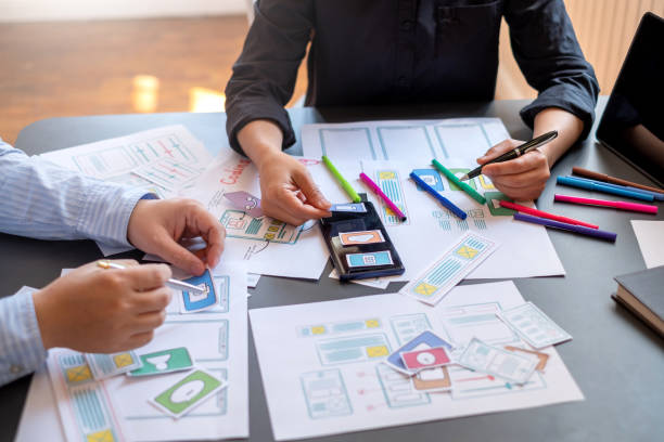 istock Two designer creativity drawing a website outline and website ux app development on mobile phone. 1171338824