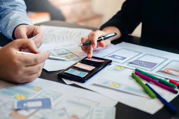 istock Two designer creativity drawing a website outline and website ux app development on mobile phone. 1171338843