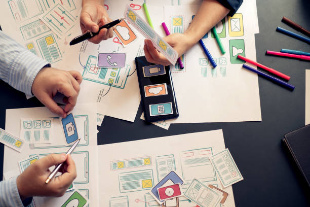 istock Two designer creativity drawing a website outline and website ux app development on mobile phone. 1171338881