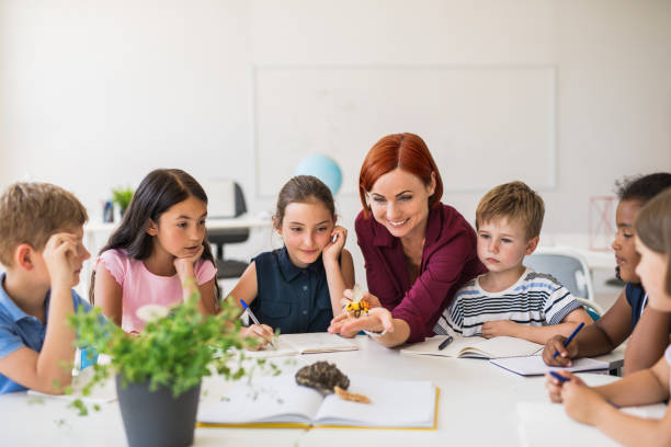 istock A group of small school kids with teacher sitting in circle in class, learning. 1171340145