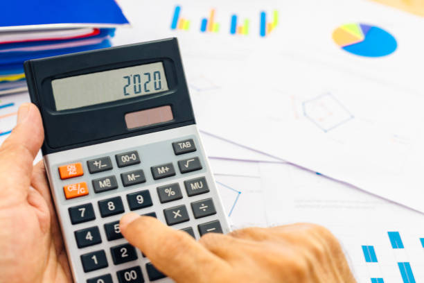 Close up accountant using calculator with 2020 number, Happy New Year 2020 Concept