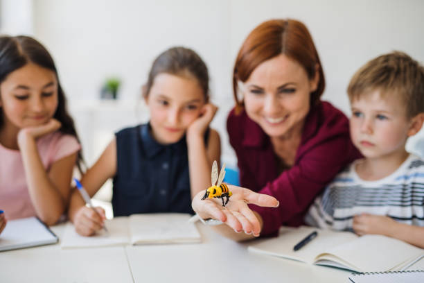 istock A group of small school kids with teacher sitting in circle in class, learning. 1171340451