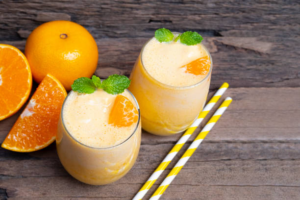 orange smoothies yellow colorful fruit juice milkshake blend beverage healthy high protein the taste yummy in glass drink to lose weight drink episode on wooden background from top view. - orange smoothie imagens e fotografias de stock