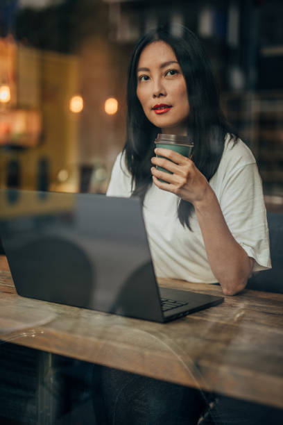Young woman working on laptop in cafe