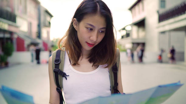 istock Cheerful beautiful young Asian backpacker woman direction and looking on location map while traveling at Chinatown in Beijing, China. Lifestyle backpack tourist travel holiday concept. 1171351515