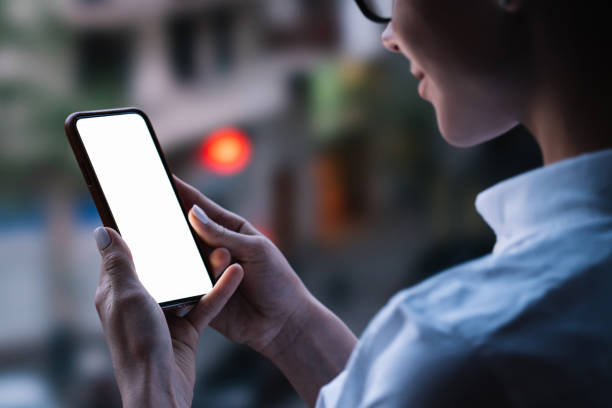 istock Woman's hands holding mobile phone with lighted big copy space touch screen outdoors with evening bokeh light of city. Close up view of female person using smartphone app for online shopping 1171354446