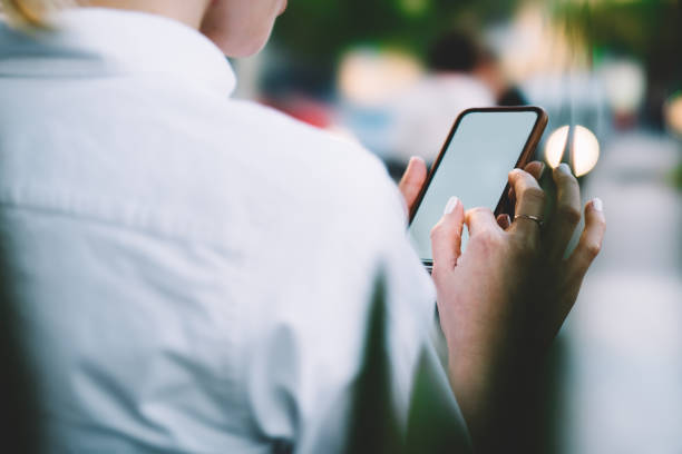 istock Cropped view of female finger installing application on display of modern smartphone using 4G internet connection.Young woman holding mobile phone in hands and chatting online on cellular device 1171354501