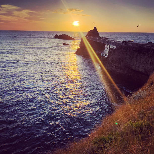 pôr do sol em biarritz, frança - rocher de la vierge - fotografias e filmes do acervo