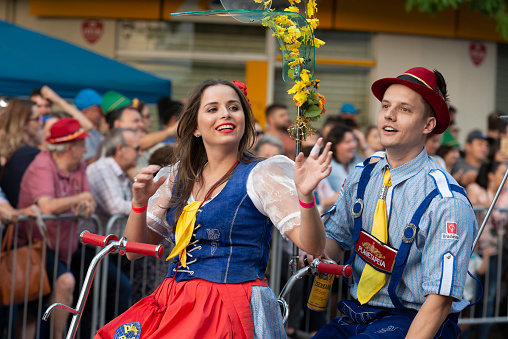 Blumenau, Santa Catarina, Brasil - October 20, 2018: Image of an young couple on a centipede bike at the Oktoberfest street parade in the heart of Blumenau city, Santa Catarina State - Brazil