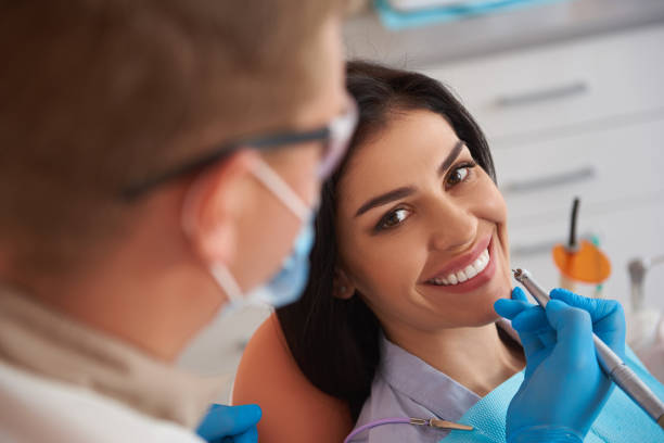 istock Stomatologist in protective mask doing professional teeth cleaning 1171363622
