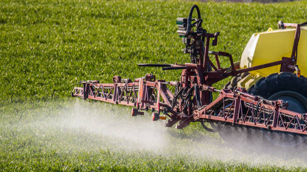 um fazendeiro pulveriza o fertilizante ou o insecticida em seu campo - farmer color image photography switzerland - fotografias e filmes do acervo