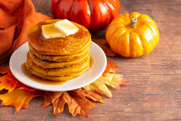 una pila di pancake aromatizzata alla spezia di zucca su un tavolo di legno - pancake foto e immagini stock