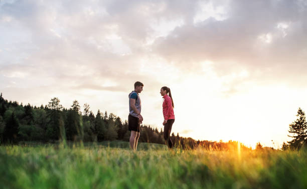 istock Active young couple resting after doing exercise in nature at sunset. 1171370289