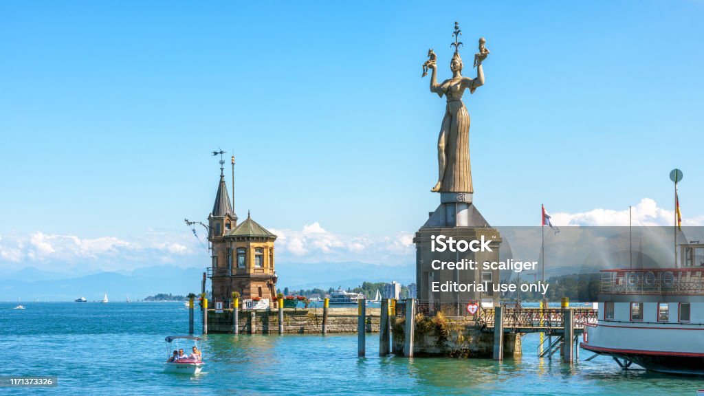 Old lighthouse and big statue of Imperia in harbor of Konstanz, Germany Constance, Germany – July 30, 2019: Old lighthouse and big statue of Imperia in harbor of Konstanz, Germany. Imperia is a landmark of the city. Panoramic view of Constance Lake (Bodensee) in summer. Konstanz Stock Photo