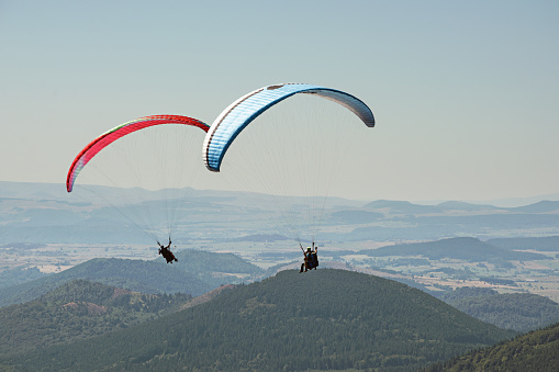Young man paragliding over a small town.