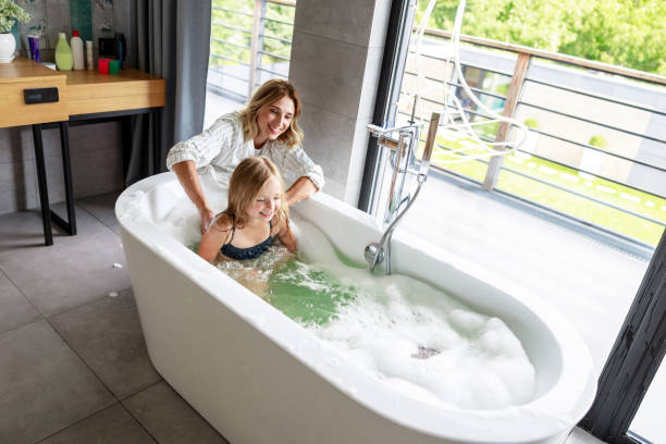istock Happy mom washing daughter in the bath 1171380445