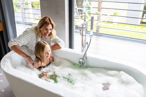 istock Happy mom is washing her daughter back 1171380838