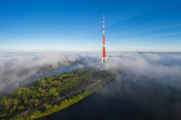 Morning fog over the Daugava river in Riga. In the foreground is the island Zakusala and the television tower