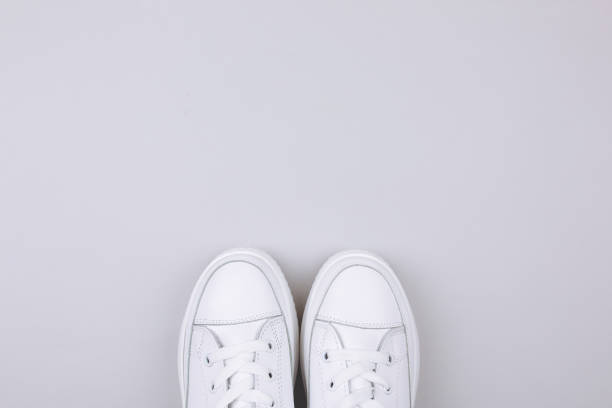 istock White sneakers on a gray background. 1171392402